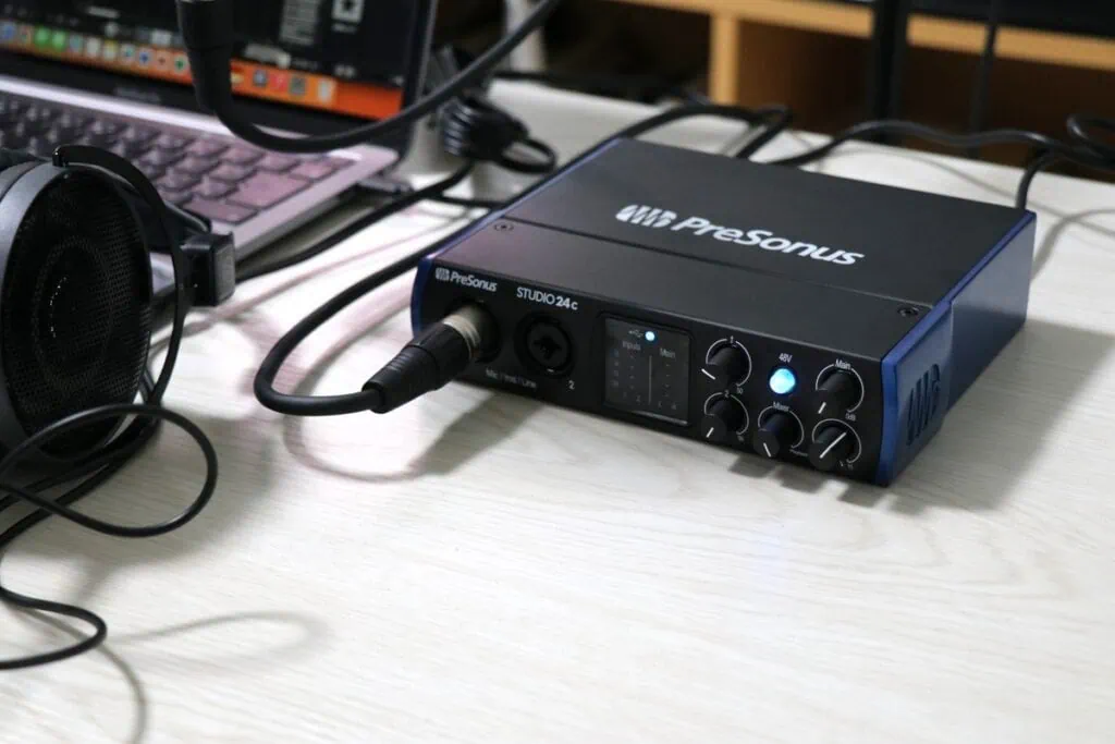 マイクとヘッドホンを繋ぎLEDが点灯しているPreSonus Studio 24c（左斜め上から）