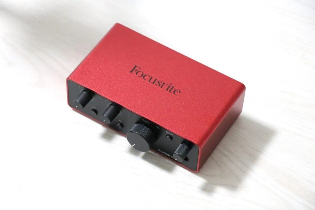 Scarlett Solo (gen. 4) を斜め上から撮影した写真。赤色の筐体に「Focusrite」のロゴ、前面パネルの操作ノブや端子類が確認できる。