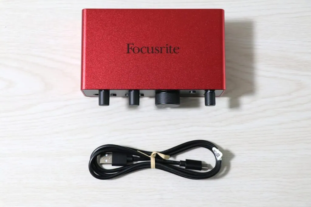 赤色のオーディオインターフェース Scarlett Solo (gen. 4)本体と付属のUSB Type-A to Type-Cケーブルが並べられた写真