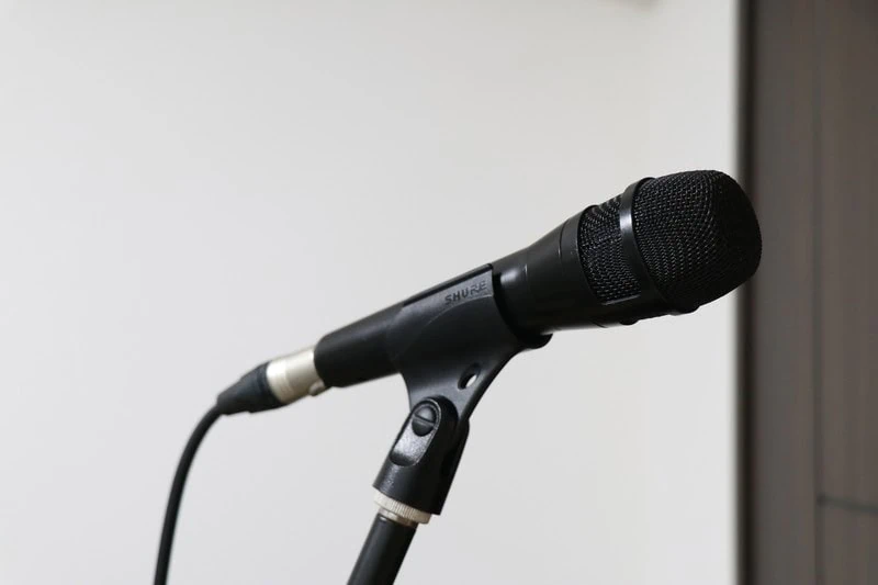 Shure Nexadyne 8のハンドヘルドマイク本体をマイクスタンドに取り付けて斜め横から撮影した商品写真