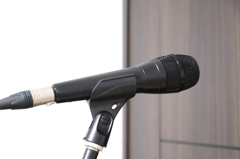 Shure Nexadyne 8のハンドヘルドマイク本体をマイクスタンドに取り付けて横から撮影した商品写真