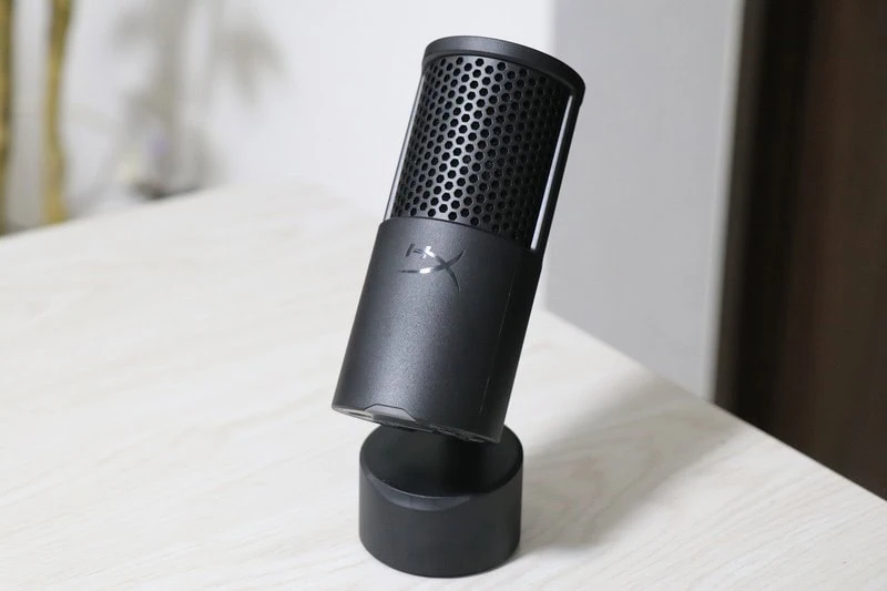 黒色のSolocast 2コンデンサーマイクが、円形の台座に立てられ、明るいデスク上に斜めに設置されている様子