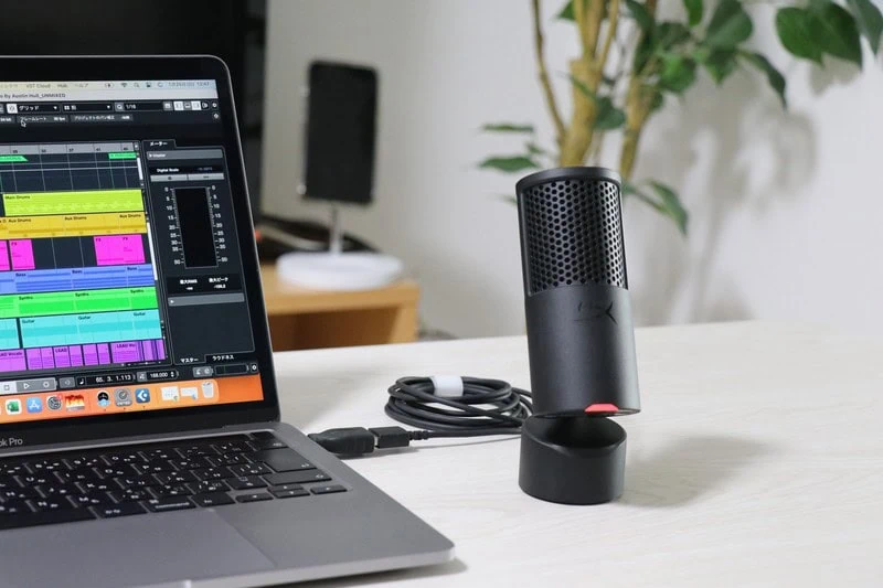 音声編集ソフトを表示したノートPCの横に、台座付きのSolocast 2マイクがデスク上に設置されている作業環境の様子