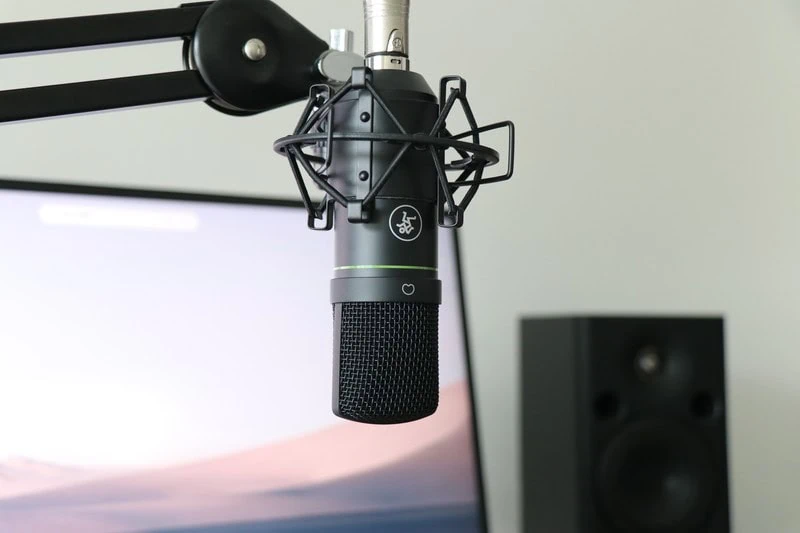 デスク上でマイクアームとショックマウントに固定されたEM-91Cコンデンサーマイクを正面から撮影した使用イメージ